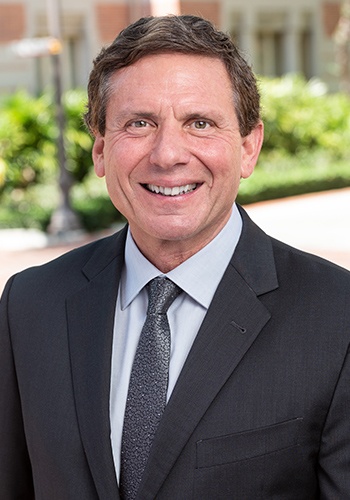 Executive Director of the Center for Transnational Law and Business, Brian Peck, stands outside and smiles at the camera.