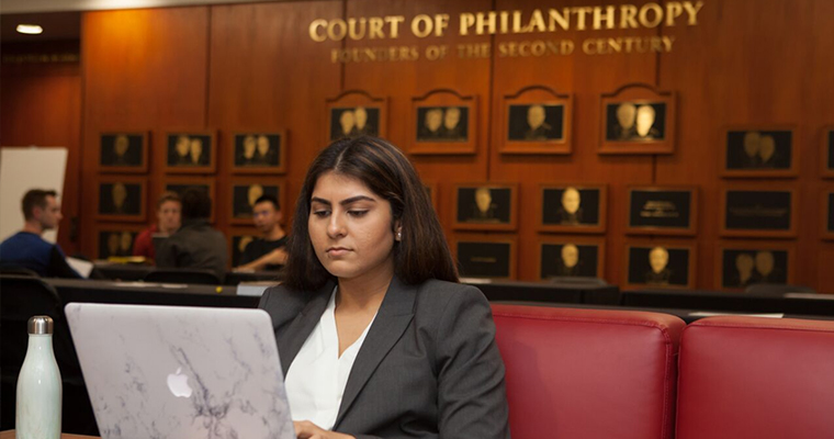 A USC Gould student studying on her Apple laptop for her Financial Compliance Certificate