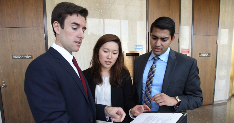 Three USC Gould students working on their Transnational Law and Business certificate reviewing a document