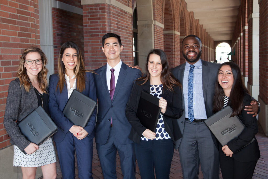 A group of students in professional attire posing on campus.