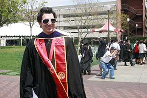 LLM alumnus, Moises Amsel wears black graduation robes and a red sash at the 2010 Gould commencement ceremony.