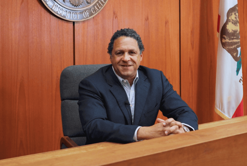 Prof. Stephen rich smiling from judges bench in courtroom.