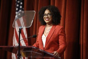 A woman smiles at a podium