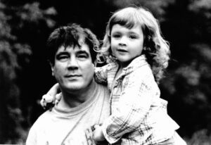 Black and white photo of a man holding a young boy, both looking at the camera