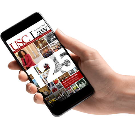 hand holding cell phone with magazine cover displayed